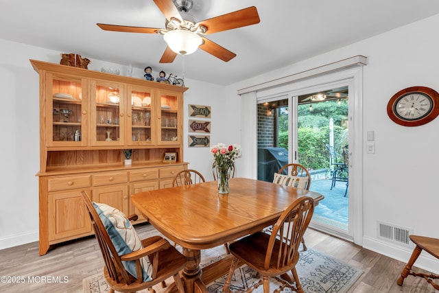 dining area with ceiling fan, baseboards, and light wood finished floors