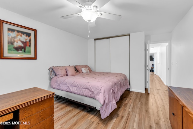 bedroom with light wood finished floors, a closet, and ceiling fan