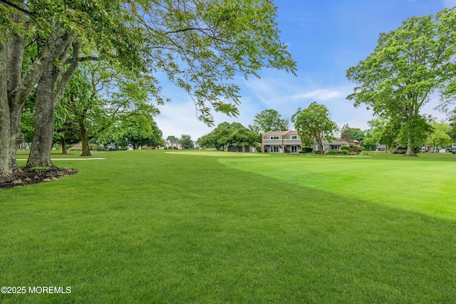view of home's community with a lawn and view of golf course
