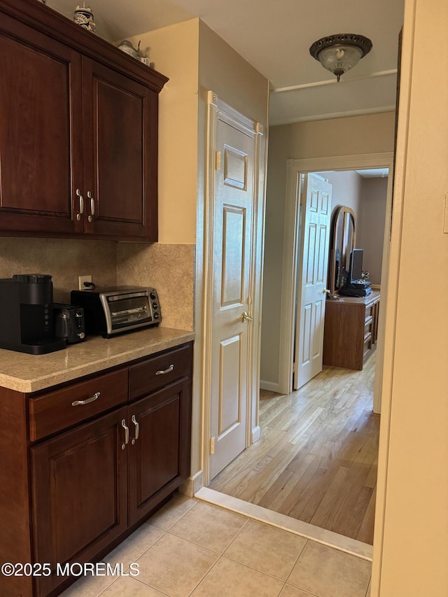 16B Robin St Unit 16B, Manchester, NJ 08759 - kitchen featuring dark brown cabinets, light countertops, light tile patterned flooring, and baseboards