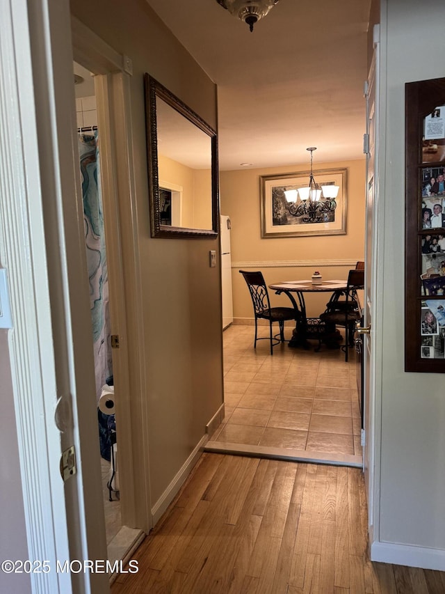 16B Robin St Unit 16B, Manchester, NJ 08759 - corridor with light wood-style floors, a chandelier, and baseboards
