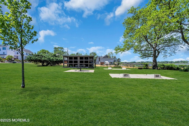 view of property's community featuring a yard and a patio