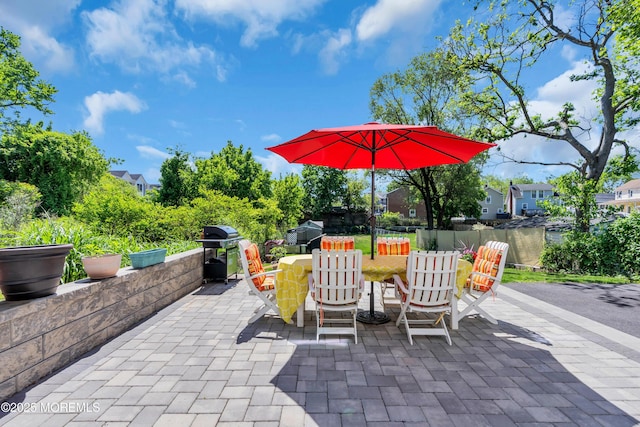 view of patio with a grill, outdoor dining space, and fence