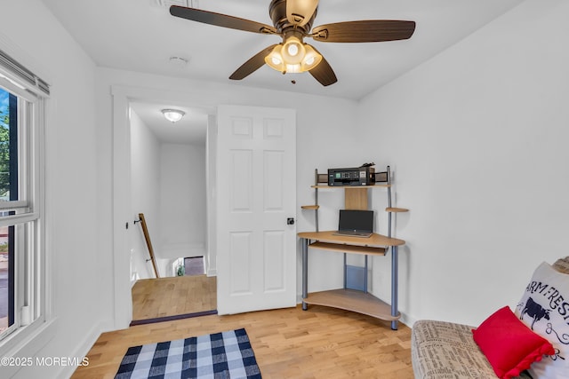 sitting room featuring an upstairs landing, light wood-type flooring, a ceiling fan, and baseboards