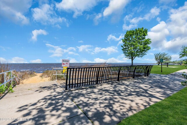 view of property's community with view of water and beach
