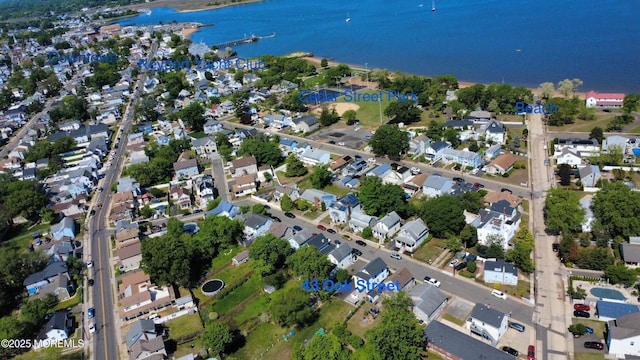 aerial view of property and surrounding area featuring a nearby body of water and nearby suburban area