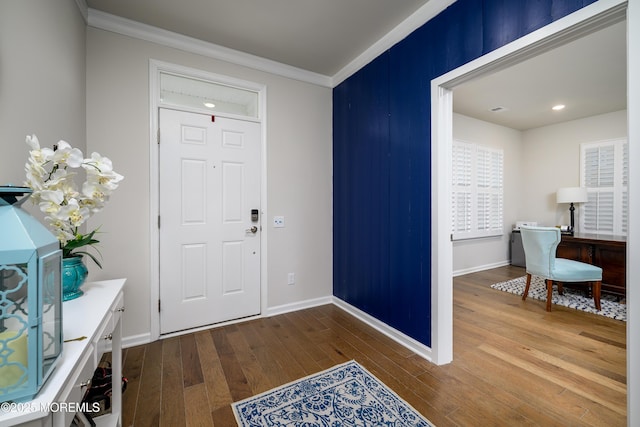entryway with hardwood / wood-style floors, crown molding, baseboards, and recessed lighting