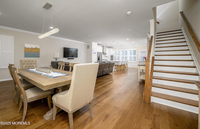 dining space featuring crown molding, stairway, light wood finished floors, recessed lighting, and baseboards