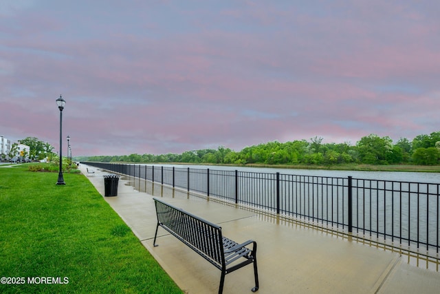 surrounding community with a yard and a water view