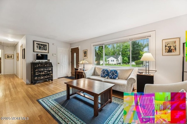 living area with attic access and wood finished floors