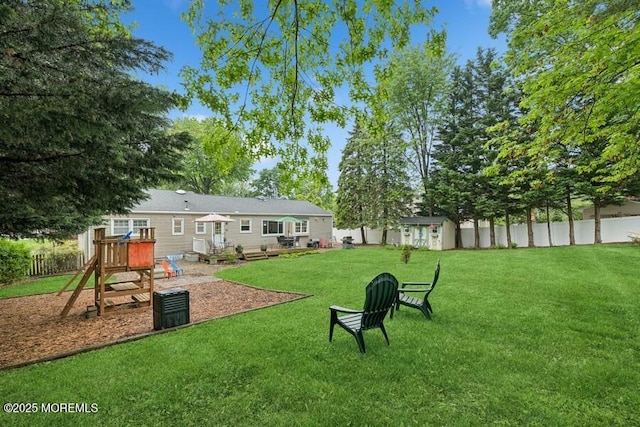 view of yard featuring a playground and an outbuilding