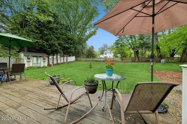 deck featuring an outdoor structure, a shed, and outdoor dining space
