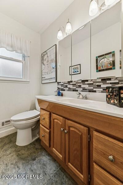 bathroom featuring toilet, tasteful backsplash, and vanity