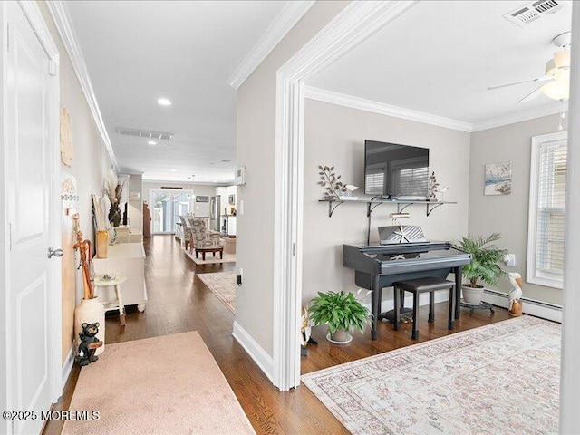 hall with baseboard heating, wood finished floors, crown molding, baseboards, and recessed lighting