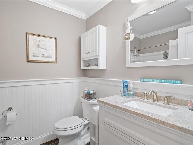 bathroom with toilet, wainscoting, ornamental molding, vanity, and curtained shower