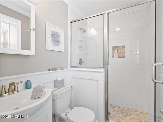 full bathroom featuring toilet, a shower stall, vanity, and ornamental molding