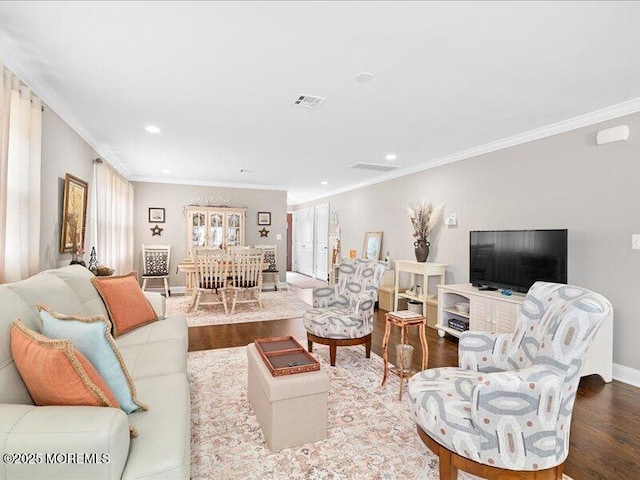 living area with wood finished floors, ornamental molding, recessed lighting, and baseboards