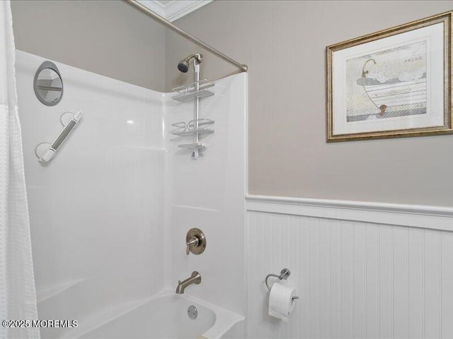full bath featuring wainscoting and shower / bath combo