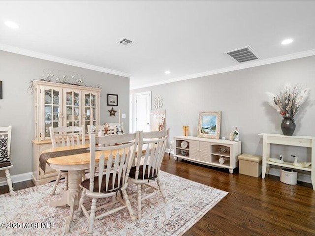 dining space featuring wood finished floors, ornamental molding, recessed lighting, and baseboards