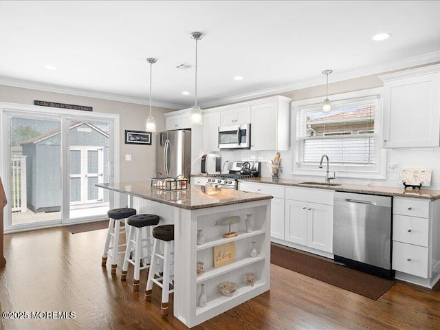 kitchen with stainless steel appliances, a sink, decorative backsplash, white cabinets, and crown molding