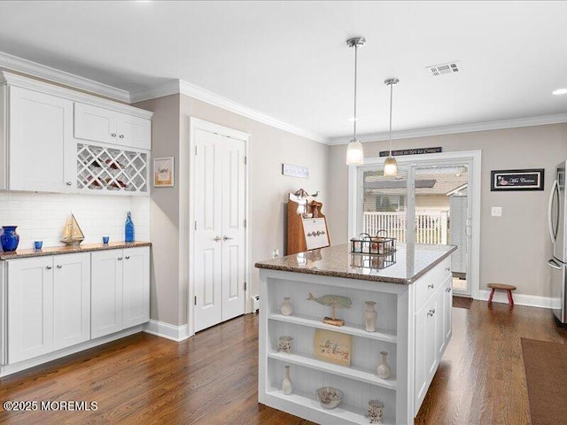 kitchen with freestanding refrigerator, baseboards, backsplash, light stone counters, and crown molding