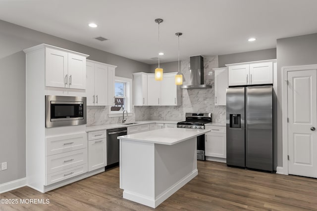 42 W Mohawk Dr, Little Egg Harbor, NJ 08087 - kitchen with appliances with stainless steel finishes, wall chimney range hood, white cabinets, a sink, and tasteful backsplash