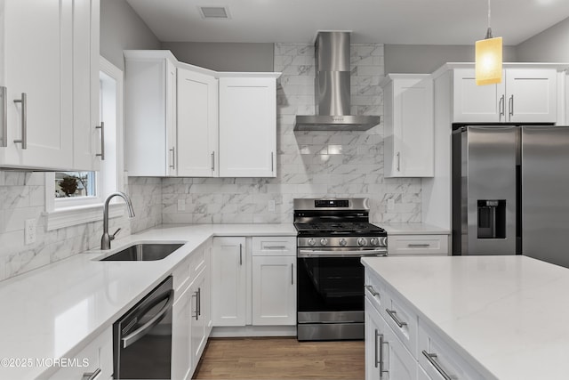 42 W Mohawk Dr, Little Egg Harbor, NJ 08087 - kitchen with stainless steel appliances, a sink, wall chimney range hood, white cabinets, and tasteful backsplash