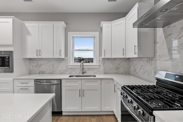 42 W Mohawk Dr, Little Egg Harbor, NJ 08087 - kitchen featuring stainless steel appliances, wall chimney range hood, a sink, and light countertops