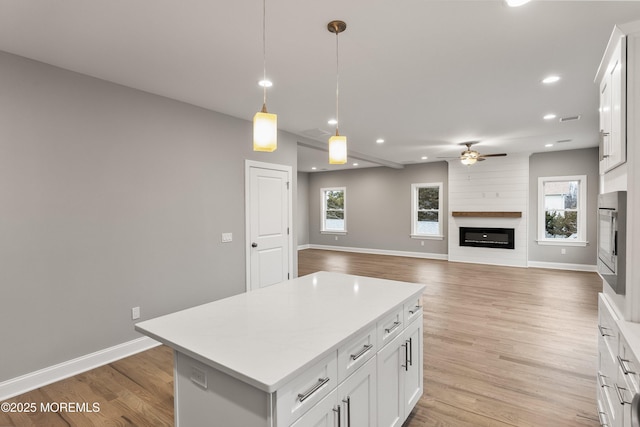 42 W Mohawk Dr, Little Egg Harbor, NJ 08087 - kitchen featuring a fireplace, a ceiling fan, light countertops, a center island, and baseboards