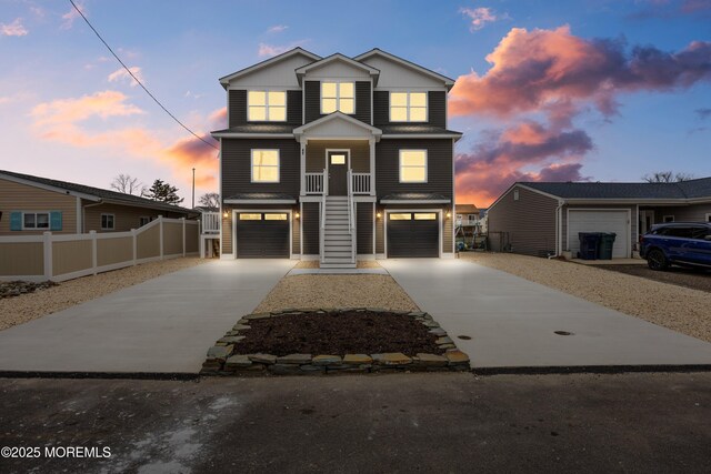 42 W Mohawk Dr, Little Egg Harbor, NJ 08087 - view of front of home with concrete driveway, an attached garage, fence, stairs, and board and batten siding