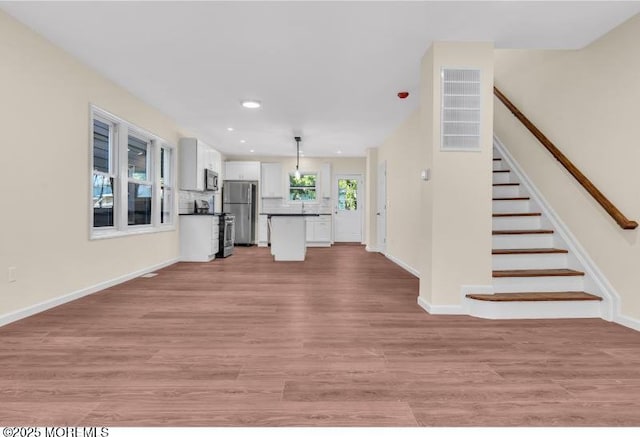 1031 3rd Ave, Asbury Park, NJ 07712 - unfurnished living room featuring light wood finished floors, recessed lighting, stairway, and baseboards