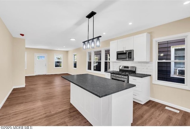 1031 3rd Ave, Asbury Park, NJ 07712 - kitchen featuring appliances with stainless steel finishes, dark countertops, white cabinetry, dark wood-style floors, and baseboards