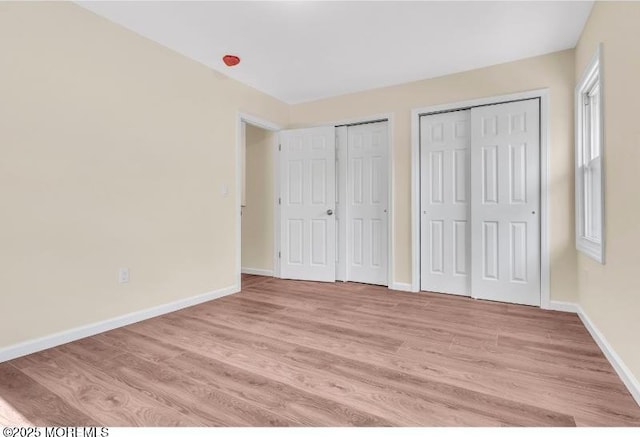 1031 3rd Ave, Asbury Park, NJ 07712 - unfurnished bedroom featuring two closets, light wood-style floors, and baseboards