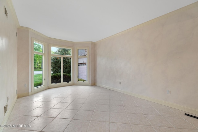 empty room featuring light tile patterned floors, crown molding, and baseboards