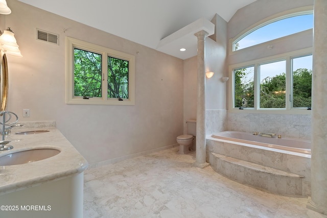full bathroom featuring a garden tub, toilet, and double vanity