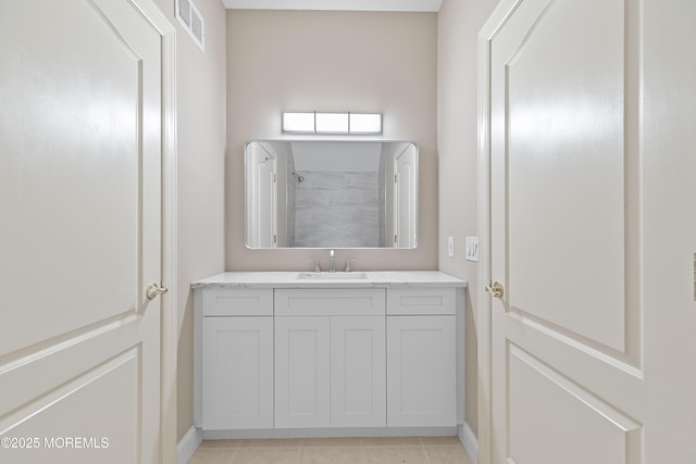 bathroom featuring vanity, baseboards, a shower, and tile patterned floors