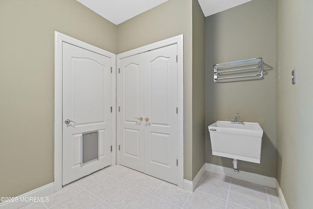 bathroom with tile patterned floors, baseboards, and a sink