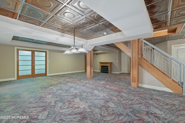 finished below grade area with carpet flooring, baseboards, stairway, and a fireplace