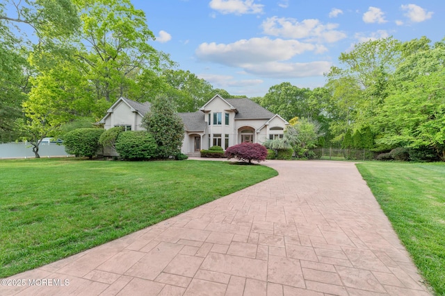 view of front facade with decorative driveway, stucco siding, and a shingled roof