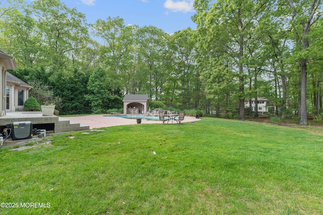 view of grassy yard featuring an outdoor pool and a deck