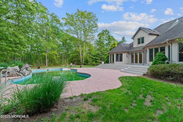 outdoor pool with a patio area and french doors
