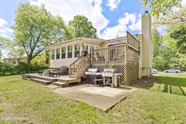 rear view of house featuring a wooden deck, a patio area, a lawn, and a chimney