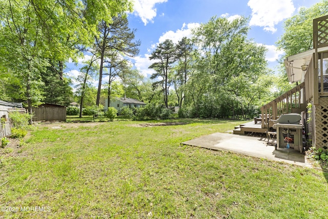 view of grassy yard with a patio, stairs, and view of scattered trees