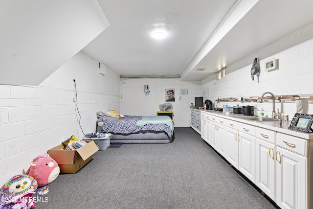 bedroom with a sink and dark carpet