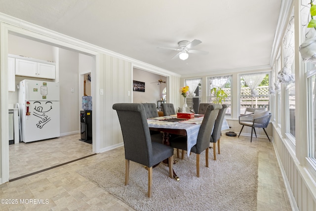 dining room with ornamental molding, ceiling fan, stone finish flooring, and baseboards