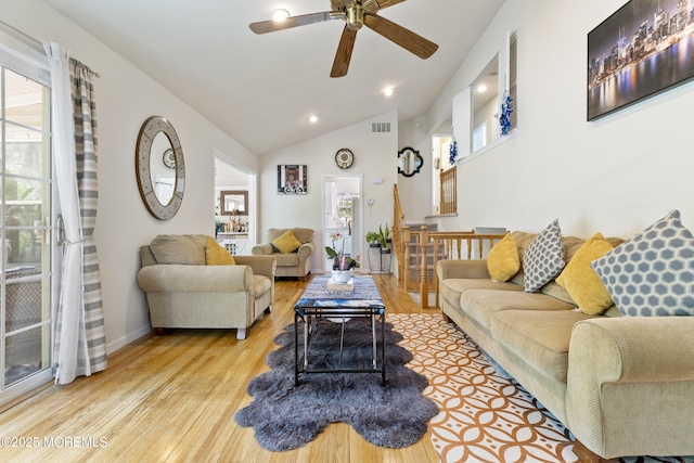 living area with wood finished floors, ceiling fan, healthy amount of natural light, vaulted ceiling, and baseboards
