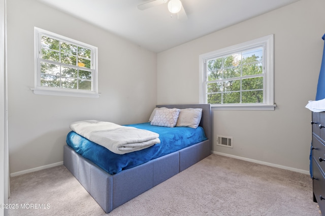 bedroom featuring multiple windows, baseboards, and carpet flooring