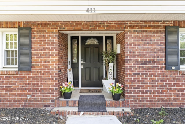 view of exterior entry with brick siding