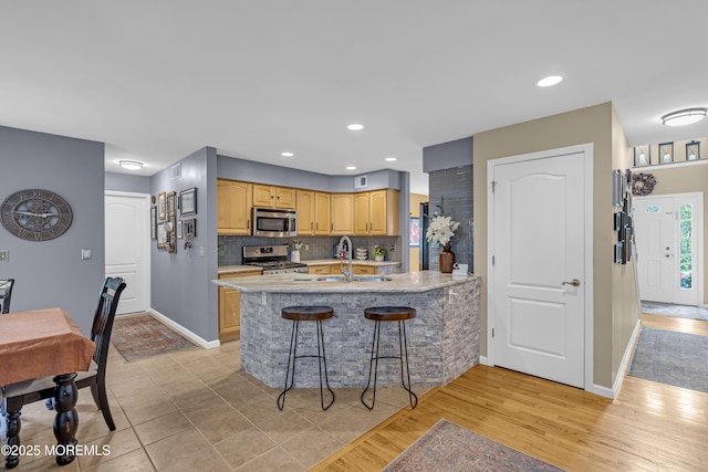13 Dori Ln, Barnegat, NJ 08005 - kitchen with stainless steel appliances, a sink, a kitchen bar, baseboards, and light countertops