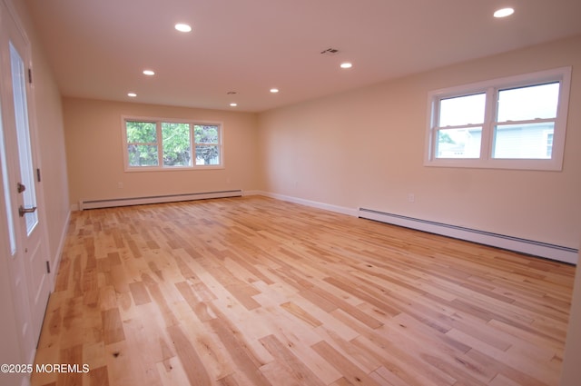 empty room with a baseboard heating unit, light wood-style floors, recessed lighting, and baseboards